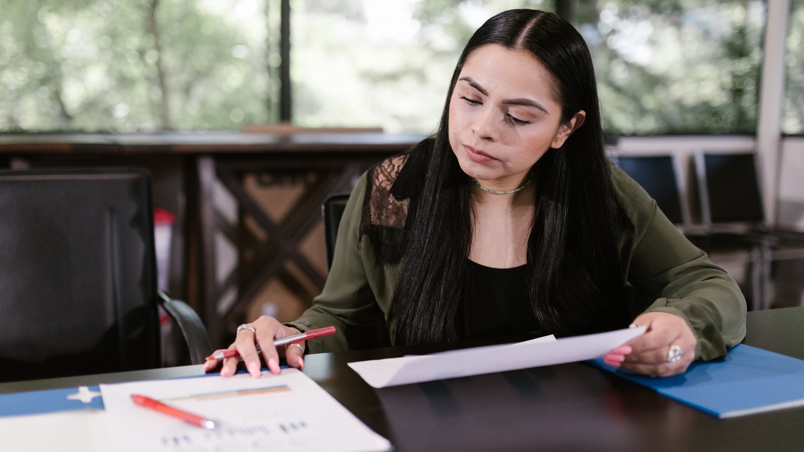 Person liest Unterlagen am Schreibtisch