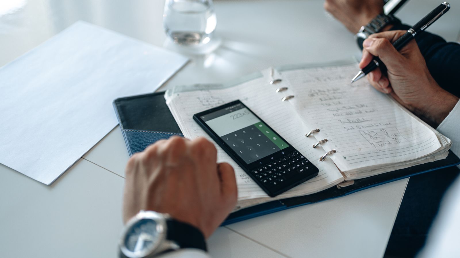 Taschenrechner, Notizblock und Unterlagen auf einem Schreibtisch